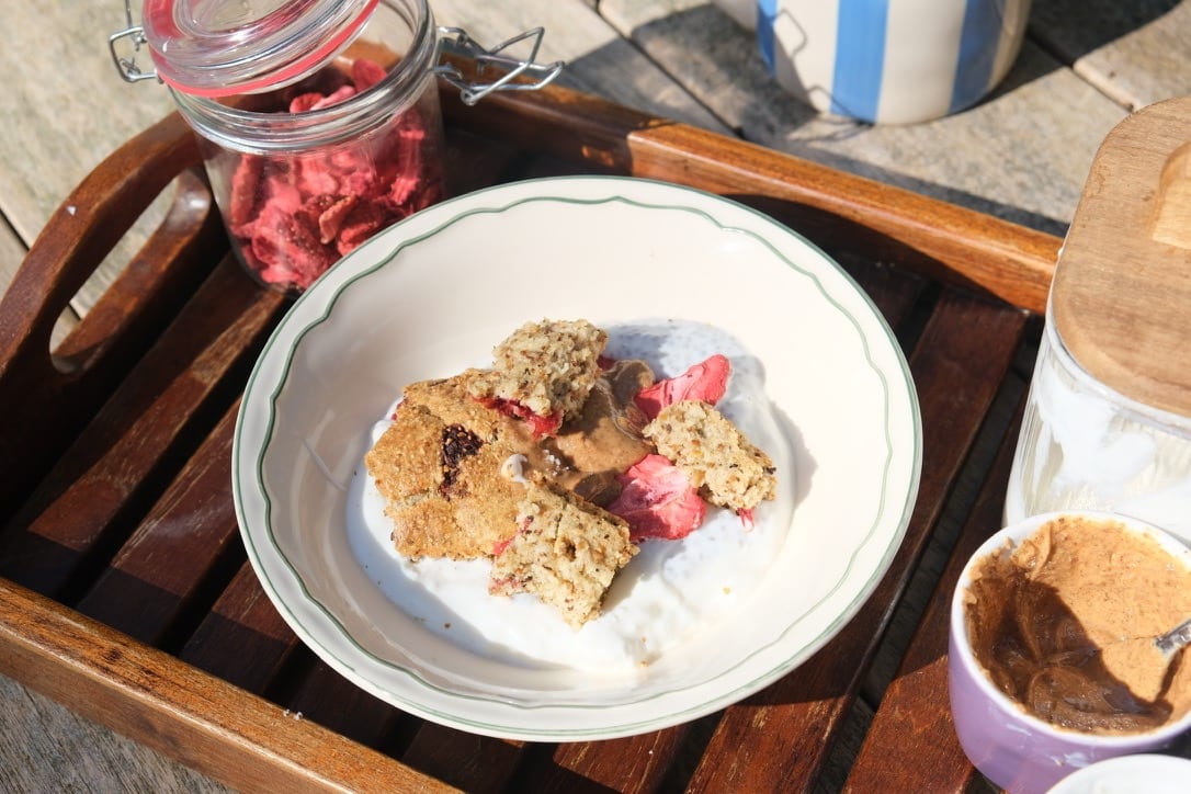 Baked Millit met frambozen en aardbeien op yoghurt, geserveerd op een houten dienblad