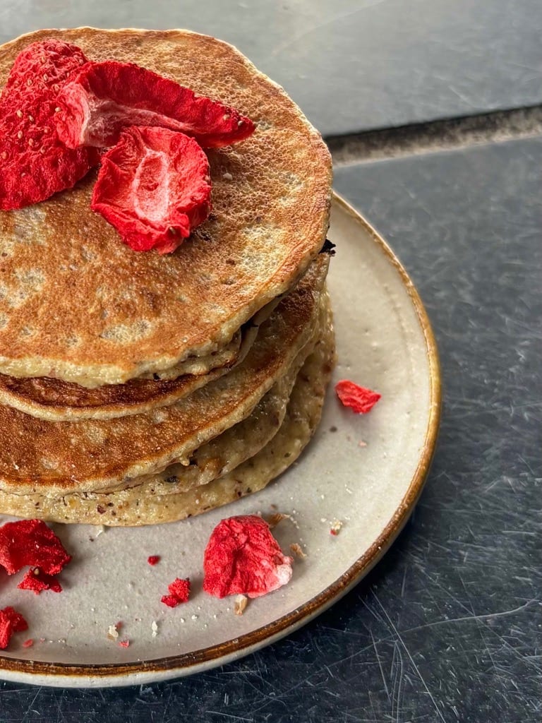 Stapel goudbruine Millit pannenkoeken met gevriesdroogde aardbeien